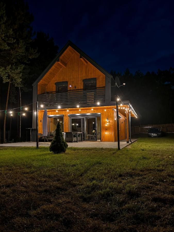 Drewniana stodoła nocą z rozświetlonym tarasem